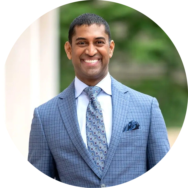 Male physician headshot in light blue blazer and patterned tie