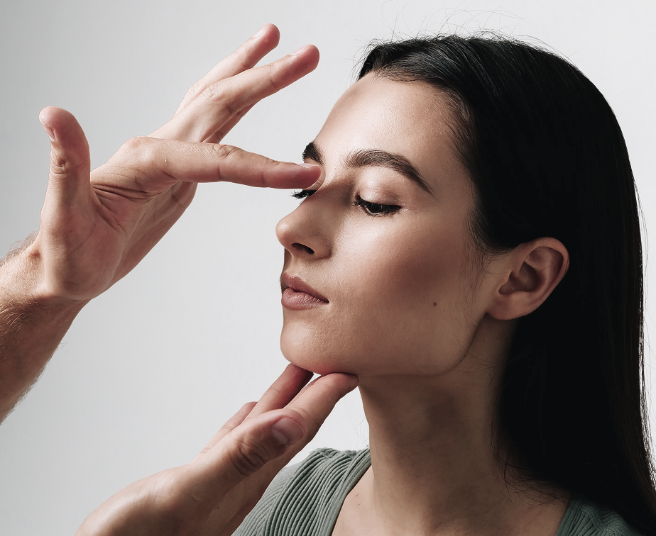 Woman in profile touching her nose