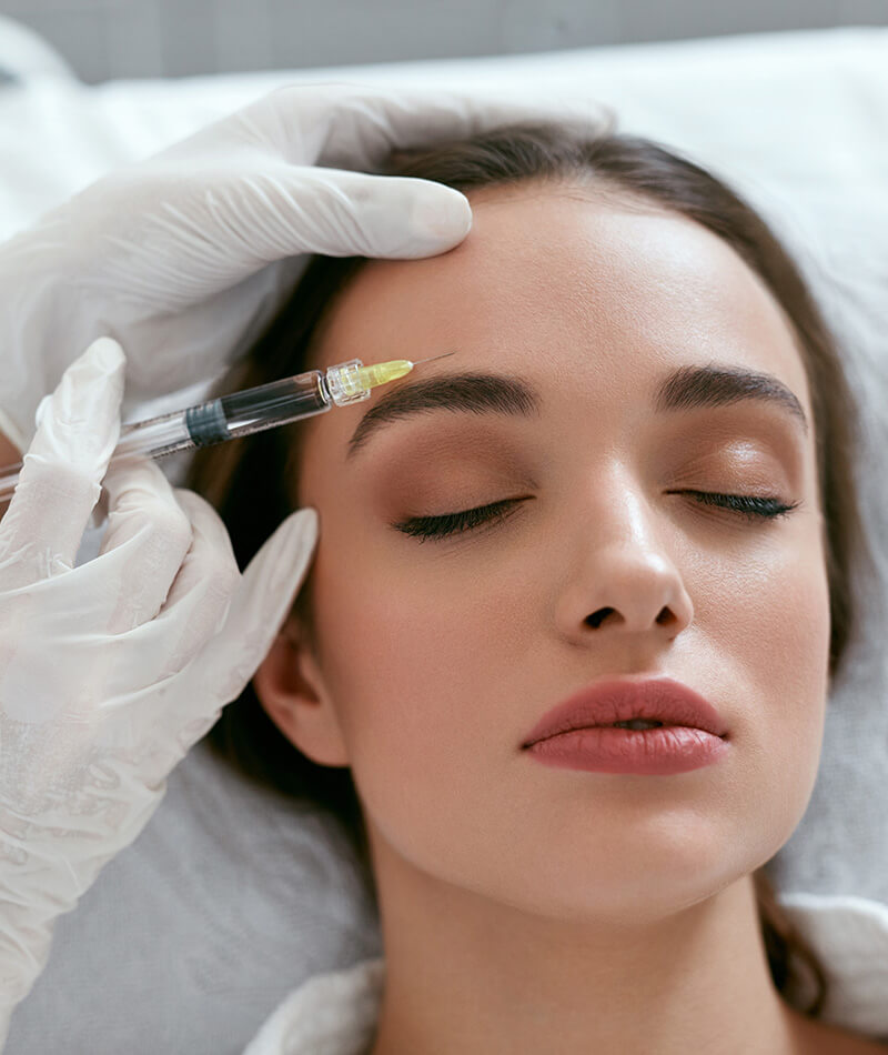 Young woman getting forehead injection